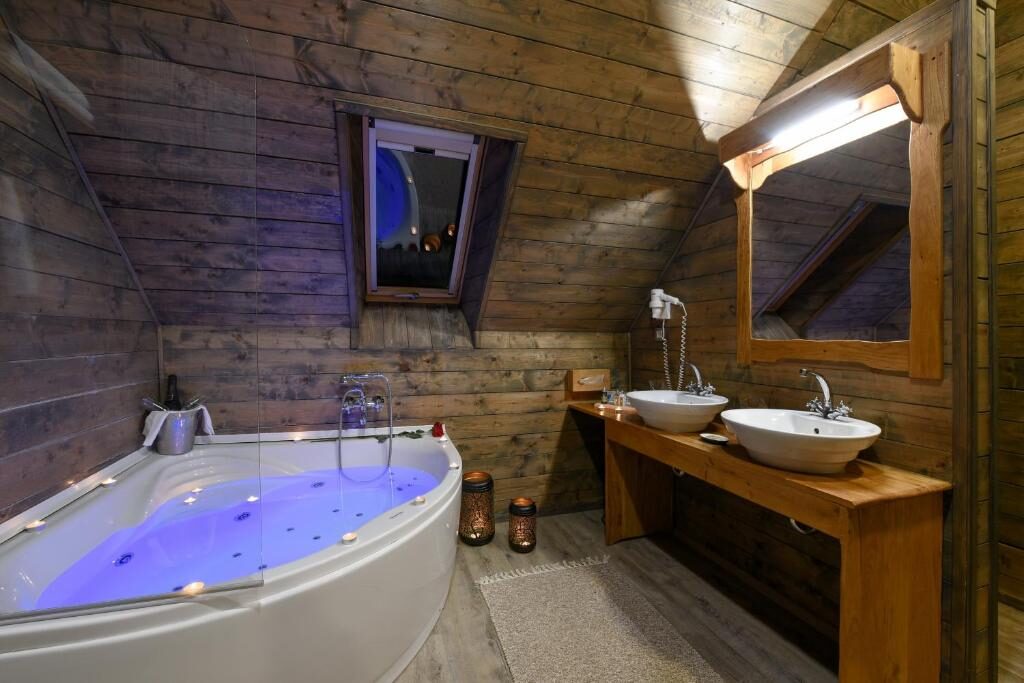 Bathroom with a corner spa bath and twin washbasins
