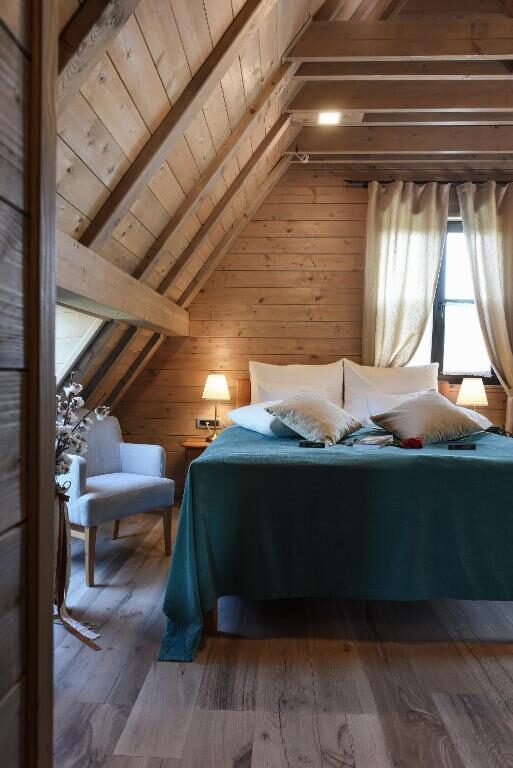 Attic room with wooden walls and a green bedspread