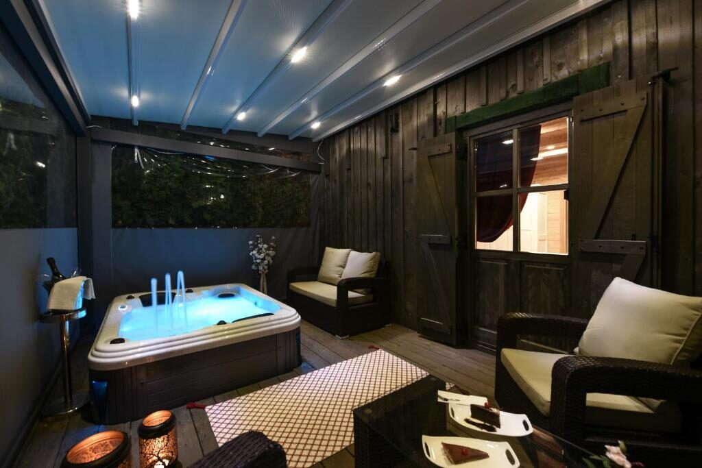 Outdoor spa area with a lit hot tub at night